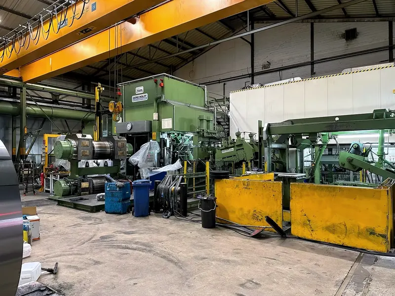 Produktionshalle mit großen Industriemaschinen und einem Hallenkran