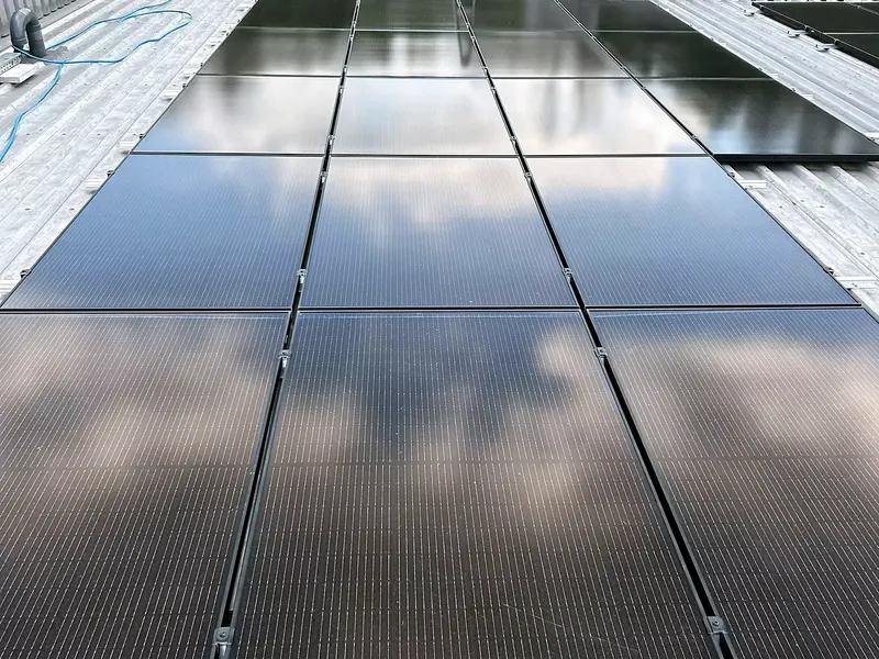Dunkle Photovoltaikmodule auf einem Hallendach